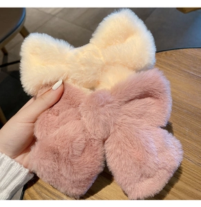 Close-up of soft plush bow hair clips in beige and pink colors with fluffy texture