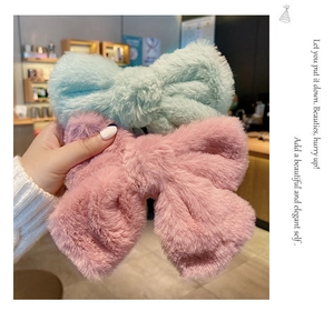 Close-up of soft plush bow hair clips in pastel blue and pink for winter hairstyles