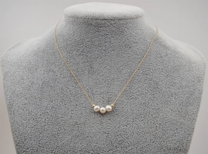 Detail of freshwater pearl necklace with gold beads on titanium steel thin chain