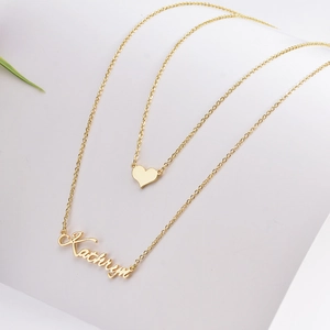 Detail of gold double-layer name necklace featuring Kathryn nameplate and heart pendant