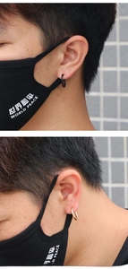 Close-up showing a black and golden titanium hoop ring worn as a fake nose or lip ring