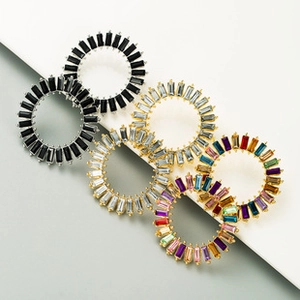 Detail of vintage round radial alloy earrings with colorful rhinestones in claw setting