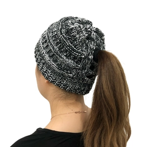 Detail view of the knitted ponytail hole on back of black and white winter beanie hat