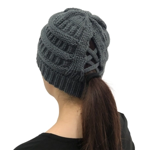 Detail of dark grey knitted beanie with functional ponytail hole design for women