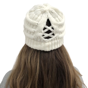 Close-up of white knitted beanie with criss-cross cutout for high ponytail hairstyle