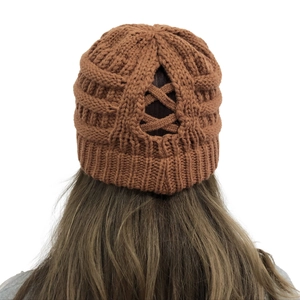 Detail view of brown knit beanie featuring a functional crisscross ponytail hole opening