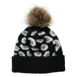 Detailed view of leopard print knit beanie with a fluffy brown pompom and black ribbed cuff