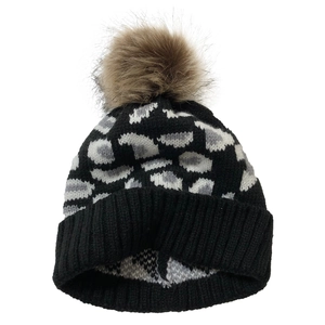 Detail of grey leopard print knit beanie with fluffy brown faux fur pom pom and ribbed cuff