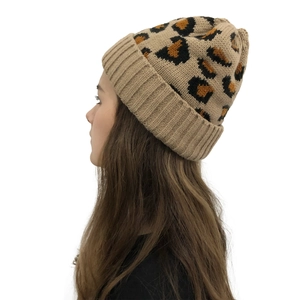 Macro detail of leopard print knit beanie texture and rolled edge on a khaki winter hat
