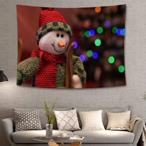 Cozy living room detail with snowman Christmas tapestry hung above a grey sofa