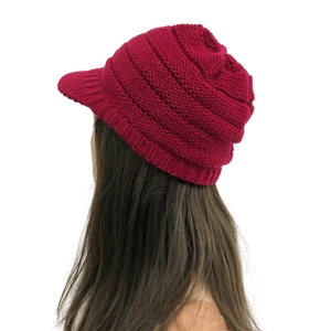 Detail of red knitted beanie with short brim showing warm ear protection and cozy winter texture