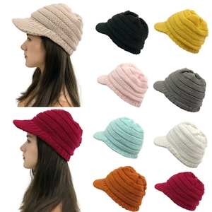 Close-up of winter knit beanie hats with visors in multiple colors and ear protection