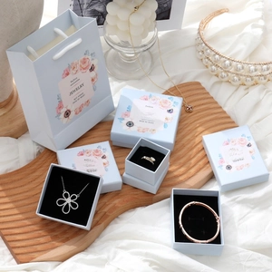 Detail of light blue jewelry gift boxes and paper bag with pink floral patterns