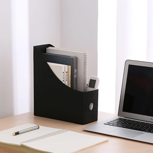 Black desk organizer magazine holder for books and office files on a minimalist wood desk