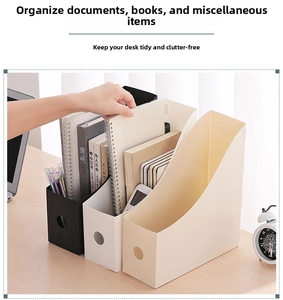 Close-up of modern plastic desk file organizers in black and cream on an office table