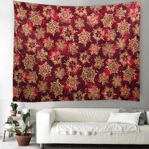 Detail of red Christmas tapestry with golden snowflake pattern hanging above a sofa