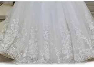 Détail d'une robe de mariée blanche avec dentelle délicate et paillettes scintillantes