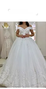 Détail de robe de mariée blanche à épaules dénudées avec broderie en dentelle et sequins