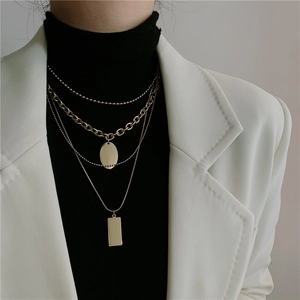 Layered gold titanium steel necklace with geometric pendants on a female model
