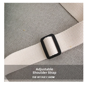 Detail of adjustable woven shoulder strap with black plastic buckle on a canvas kid bag