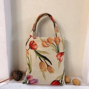 Detailed macro texture of vintage tulip jacquard fabric on a beige tote handbag