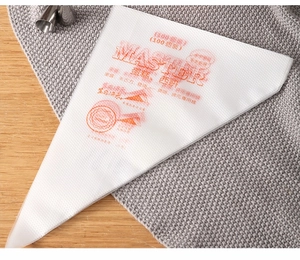 Détail de 100 poches à douille texturées pour crème et confiture sur un tapis gris et bois