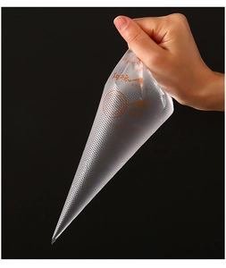Gros plan d'une main tenant une petite poche à douille transparente avec inscriptions orange