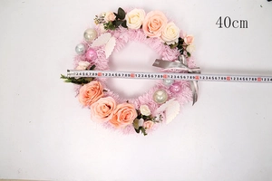 Close-up of 40cm Christmas wreath with pink roses, mirror balls, and Happy everyday ribbon