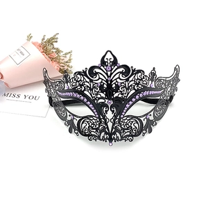 Detail of laser-cut black metal masquerade mask with purple rhinestones and baroque patterns