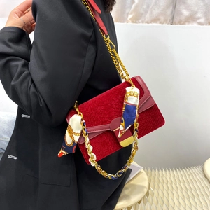 Elegante borsa rossa a pelle di serpente con catena dorata e foulard su modella