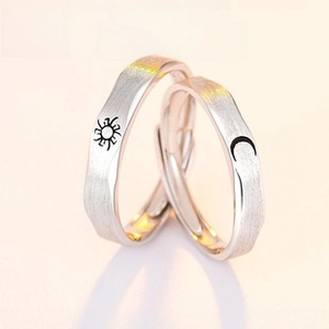 Detail of adjustable S925 silver couple rings featuring sun and moon brushed metal finish