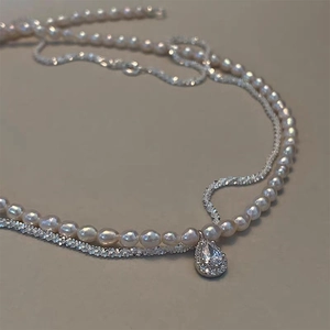 Detail of double-layer necklace with rice pearls and a teardrop-shaped zircon pendant