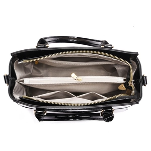 Vue intérieure du sac à main en cuir verni noir avec compartiments et garnitures dorées