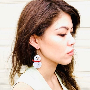 Cute snowman earrings with red glitter scarf worn by model for Christmas festive style