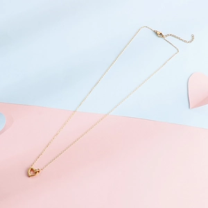 Hollow heart stainless steel necklace with sparkling zircon pendant on pink and blue backdrop