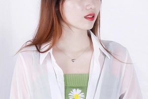Close-up of a silver hollow heart-shaped pendant necklace worn by a fashion model
