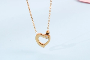 Close-up of golden heart pendant with a crystal-studded connector on a necklace