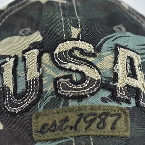 Detailed close-up of USA embroidery and distressed camo fabric on vintage baseball cap