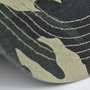 Detailed close-up of stitched brim on camouflage cotton baseball cap with American flag