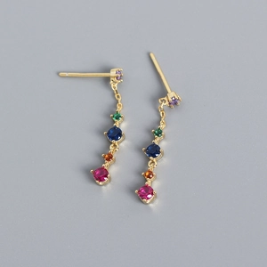 Detailed shot of long gold earrings with cascading colorful round rainbow zircons