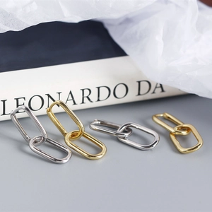 Detail shot of interlocking oval earrings in gold and silver finish with metallic shine