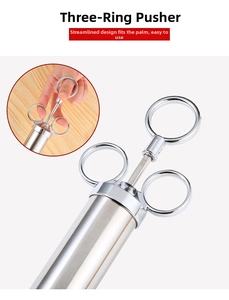 Détail montrant la poignée à trois anneaux et le piston de la seringue en acier