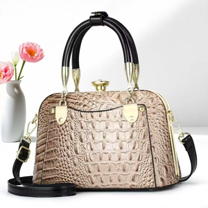 Detailed view of the gold-tone clasp and crocodile-textured leather on the women's handbag