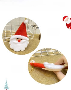 Detail of plush Santa Claus ornament with red and white fabric and gold hanging string