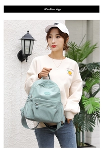 Close-up of the stylish mint green backpack featuring silver zippers and adjustable straps