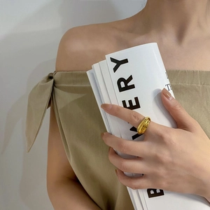 Detailweergave van een onregelmatige dikke gouden ring met hoogglansafwerking aan de vinger