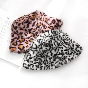 Plüsch-Anglerhüte mit Leopardenmuster in Rosa und Schwarz auf einem weißen Buch