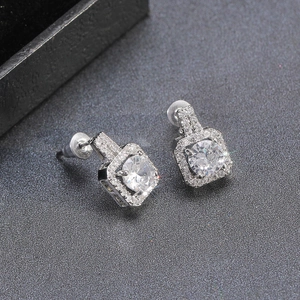 Macro detail of square silver stud earrings featuring brilliant halo zircon setting