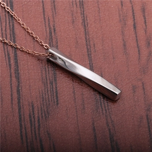 Bar pendant necklace with silver finish and rose gold chain on leather background