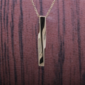 Minimalist gold titanium steel twisted bar pendant necklace on wood grain background